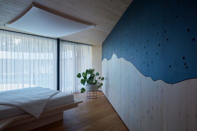 A bedroom with a wall painted blue with a white blob underneath it