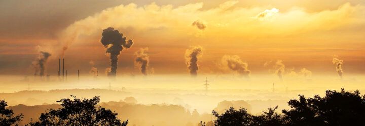 A landscape showing several smokestacks.