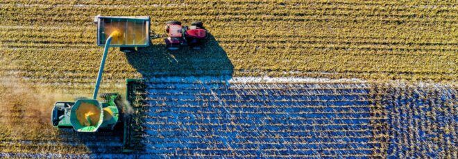 An aerial view of a machine farming a field.