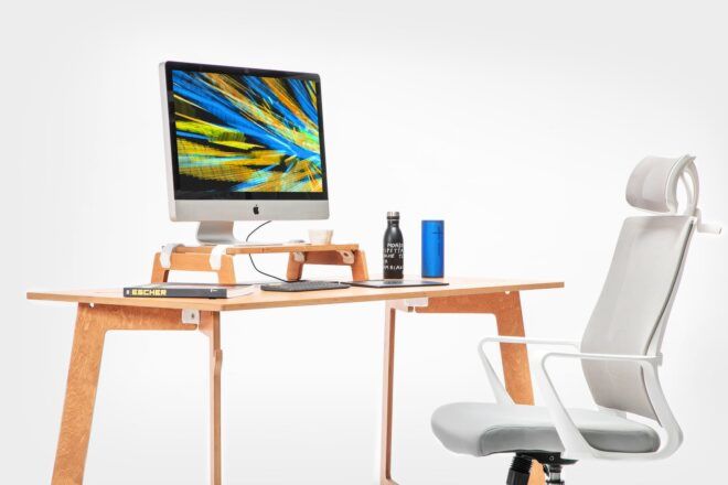 A desk with a white office chair and a Apple computer on the desk