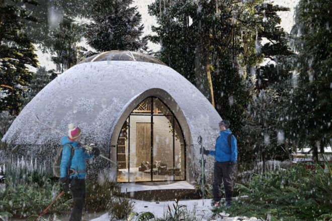 Two people in blue jackets standing outside a white glamping dome.
