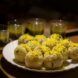 A white plate holding fried balls sprinkled with garnish