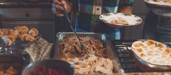A person scooping food set in trays