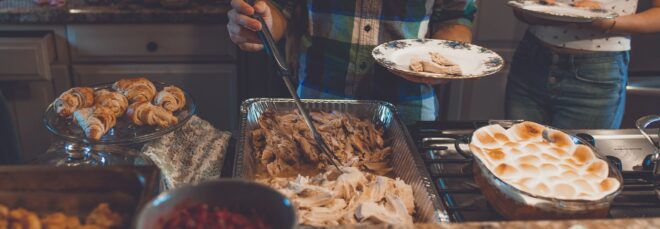 A person scooping food set in trays