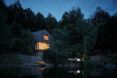 A night view of a home by a lake.