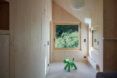 A wood halway with a green dog-like toy on the floor.