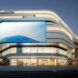 A futuristic-looking glass building with a large screen in front of it