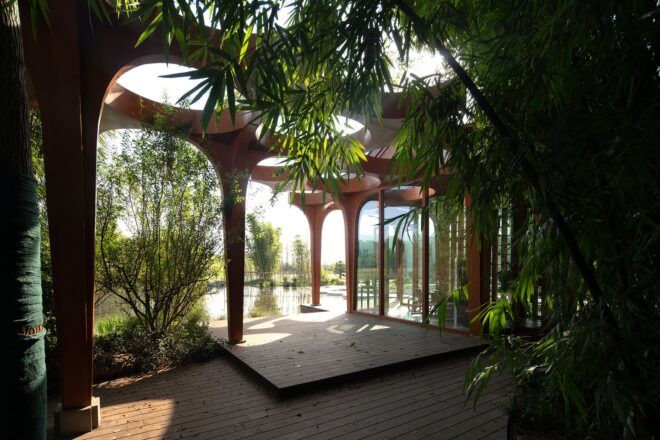 Open pavilion with arches that blend with the bamboo planted there