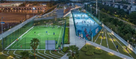 A narrow strip filled with green space and sport fields