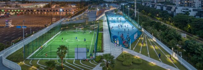 A narrow strip filled with green space and sport fields