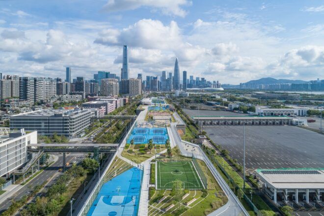 A narrow strip filled with green space and sport fields