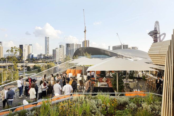 A rooftop patio with many people gathered.