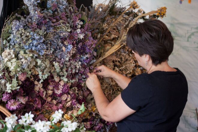 Amanda Bayha weaving flowers in a large bouquet