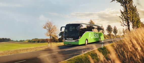 A green bus driving down a highway