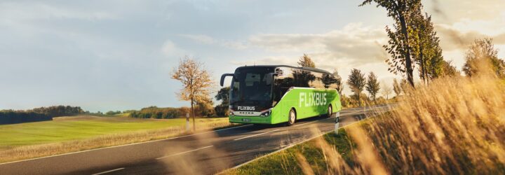 A green bus driving down a highway