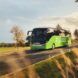 A green bus driving down a highway