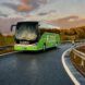 A green bus driving down a highway