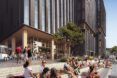 People sitting in a courtyard outside a tall building.