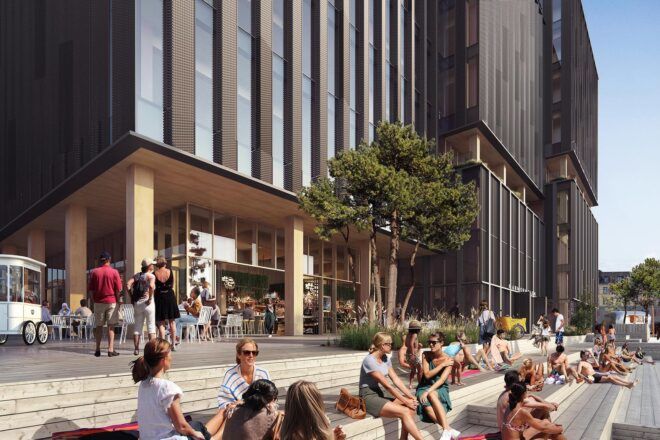 People sitting in a courtyard outside a tall building.