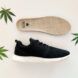 A pair of black and white sneakers surrounded by three hemp leaves.