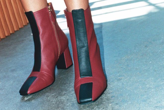 A pair of red ankle boots with black exclamation points on them.