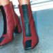 A pair of red ankle boots with black exclamation points on them.