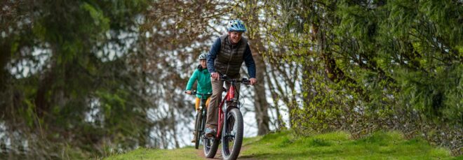 Two people riding on bikes downhill in a line