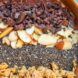 A bowl filled with chocolate syrup, almond, chia seeds and granola