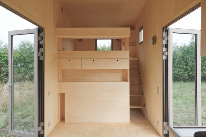 Both glass doors are open on either side of the main living room