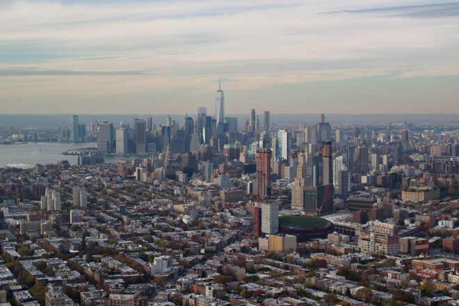 Aerial stock photo of skyscrapers in the downtown area of Brooklyn, with the Lower Manhattan skyline in the background in autumn; Brooklyn and Lower Manhattan, New York City.
