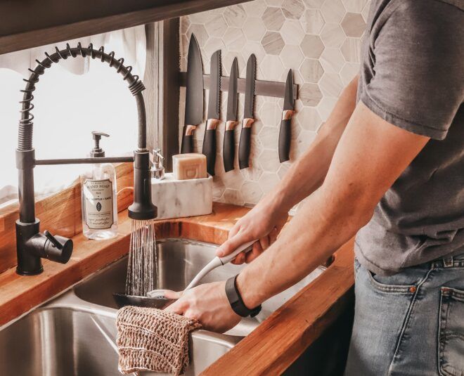 A person is washing something in a sink