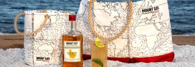 A beverage bucket, tote bag, bottle of alcohol and a cup of alcoholic beverage