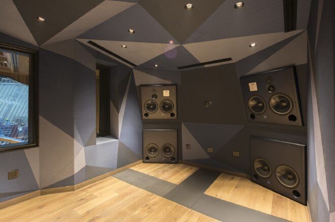 A wall of speakers with geometric patterns painted on the wall