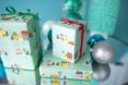 Three boxes wrapped in a blue wrapping paper with silver ornaments decorating around it