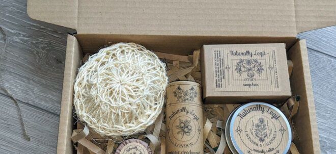 A cardboard box filled with home goods like tin boxes of soap