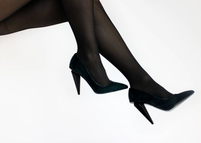A pair of legs wearing black heels.