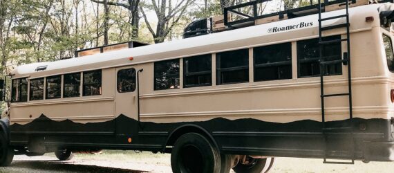 A school bus sits in a forest
