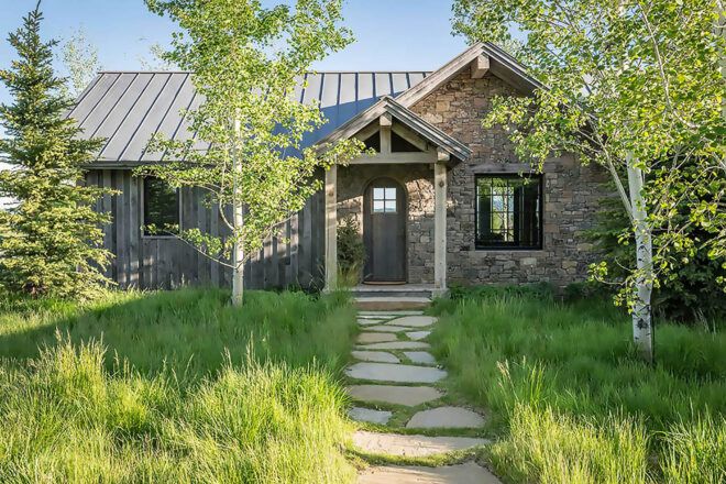 The exterior of a wood and stone cabin.