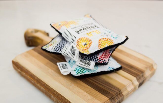 Three reusable sponges stacked on top of each other on a cutting board