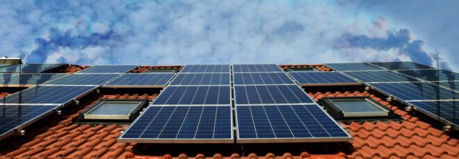 Solar panels on a roof with an overlay of smokestacks.