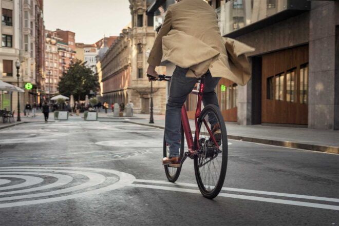 A person riding a bike down the street.