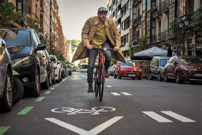 A person riding a bike down the street.