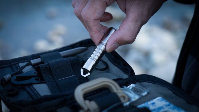 A hand pinching the tool above an open tool kit