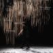 Long exposure image of an individual walking on-stage behind the installation