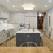 A kitchen area with a granite island and white cabinets
