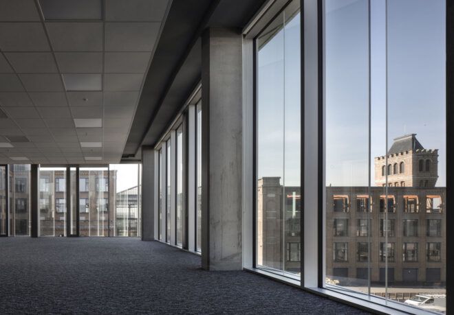 An open plan office interior surrounded by glass walls.