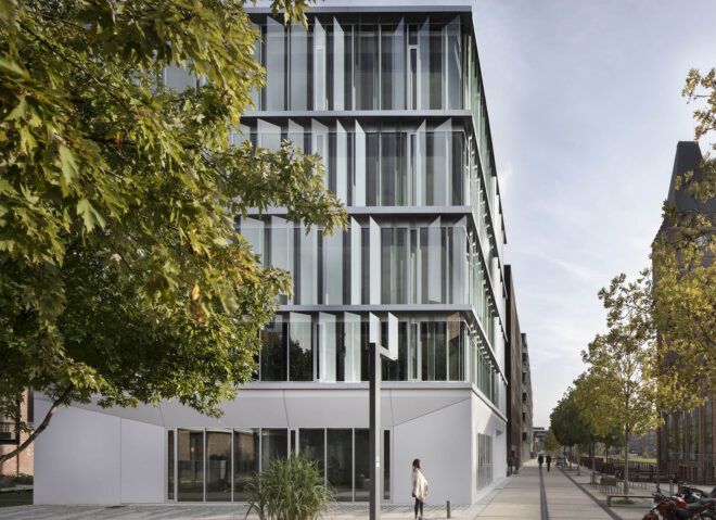 The Lucio building's exterior, showing reflective panes and a tree to the left.