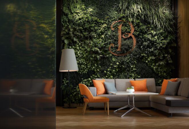 A wall filled with plants and the the letter B enmeshed in it