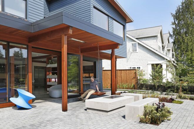 A blue house that opens onto a patio for indoor-outdoor living.