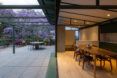 A modern apartment with a courtyard that connects to open glass doors.